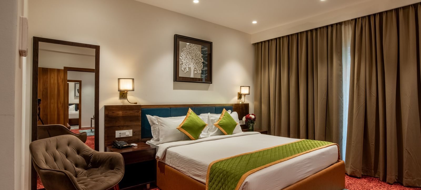 Spacious guest room with king size bed and seating area at Hotel Royal Regency Chennai
