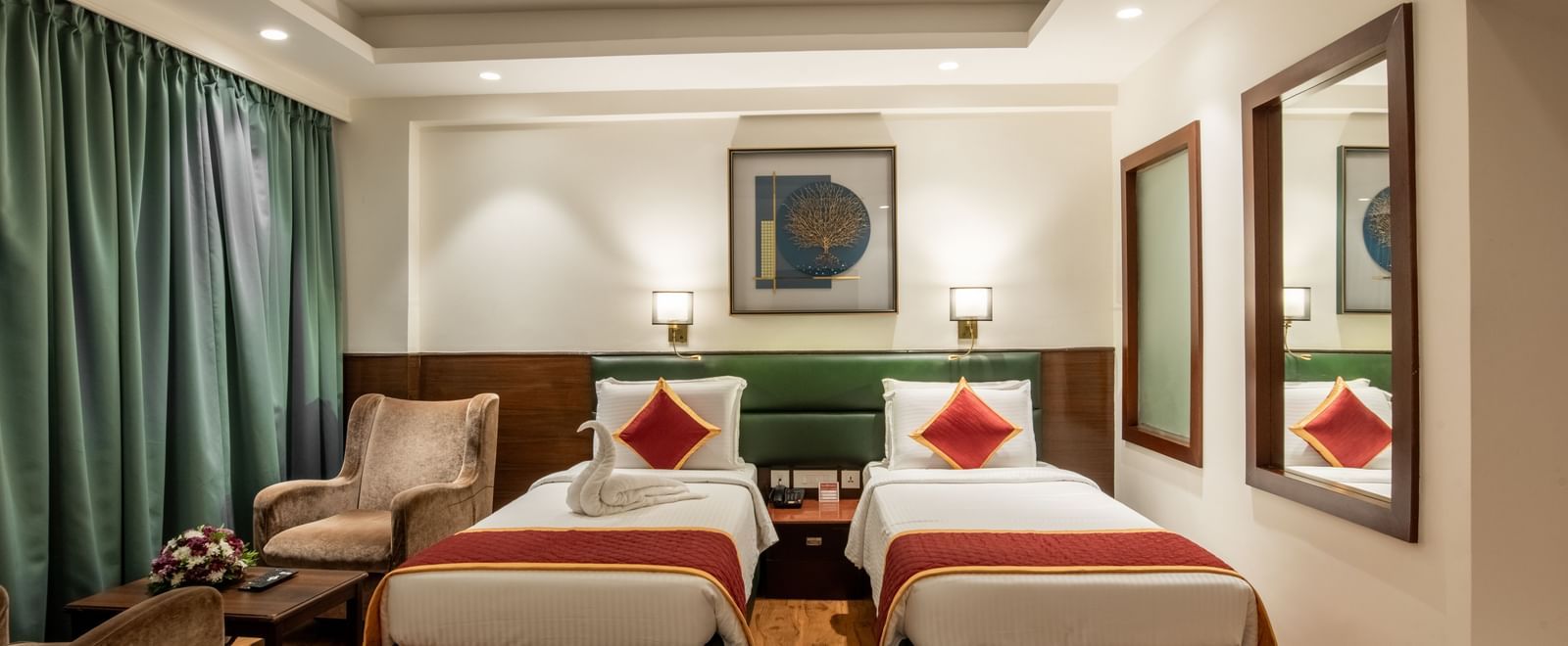 Room with twin beds, armchairs, and framed artwork at Hotel Royal Regency Chennai