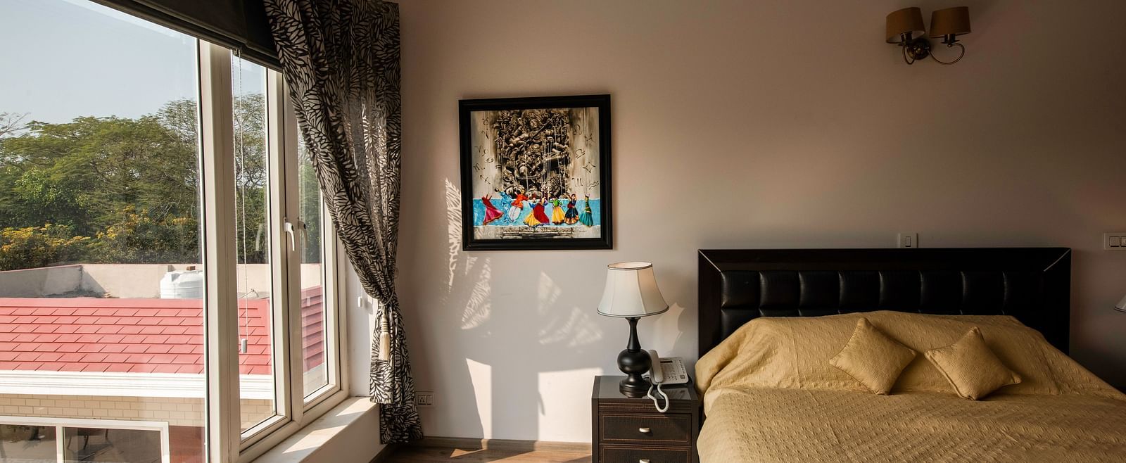 A view of a room with a bed side table and big glass windows at BluSlazz Resort.