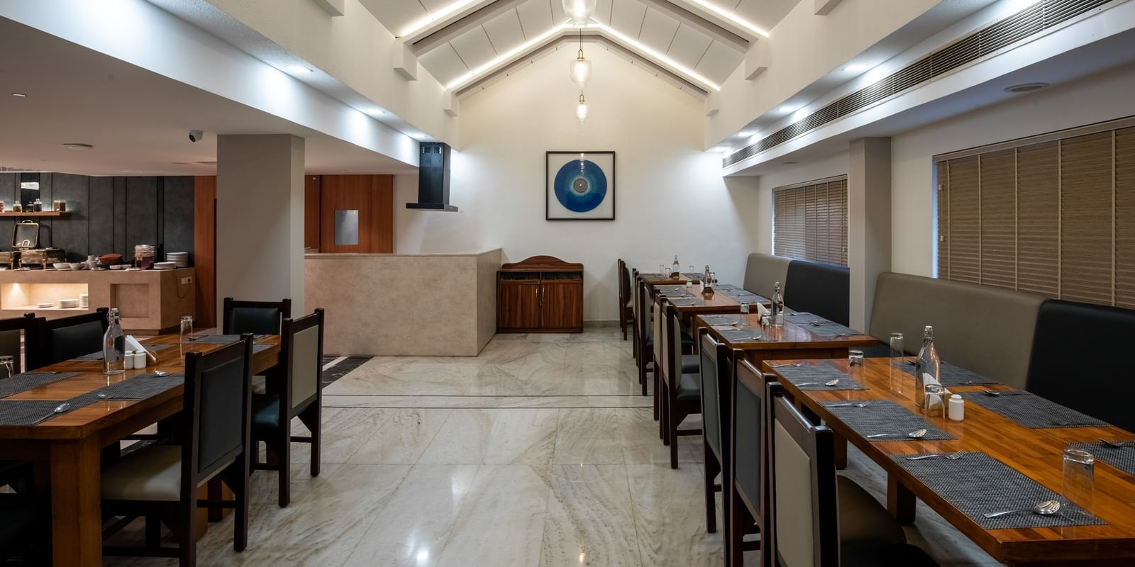 Well-lit restaurant with contemporary seating arrangement at Hotel Royal Regency Chennai