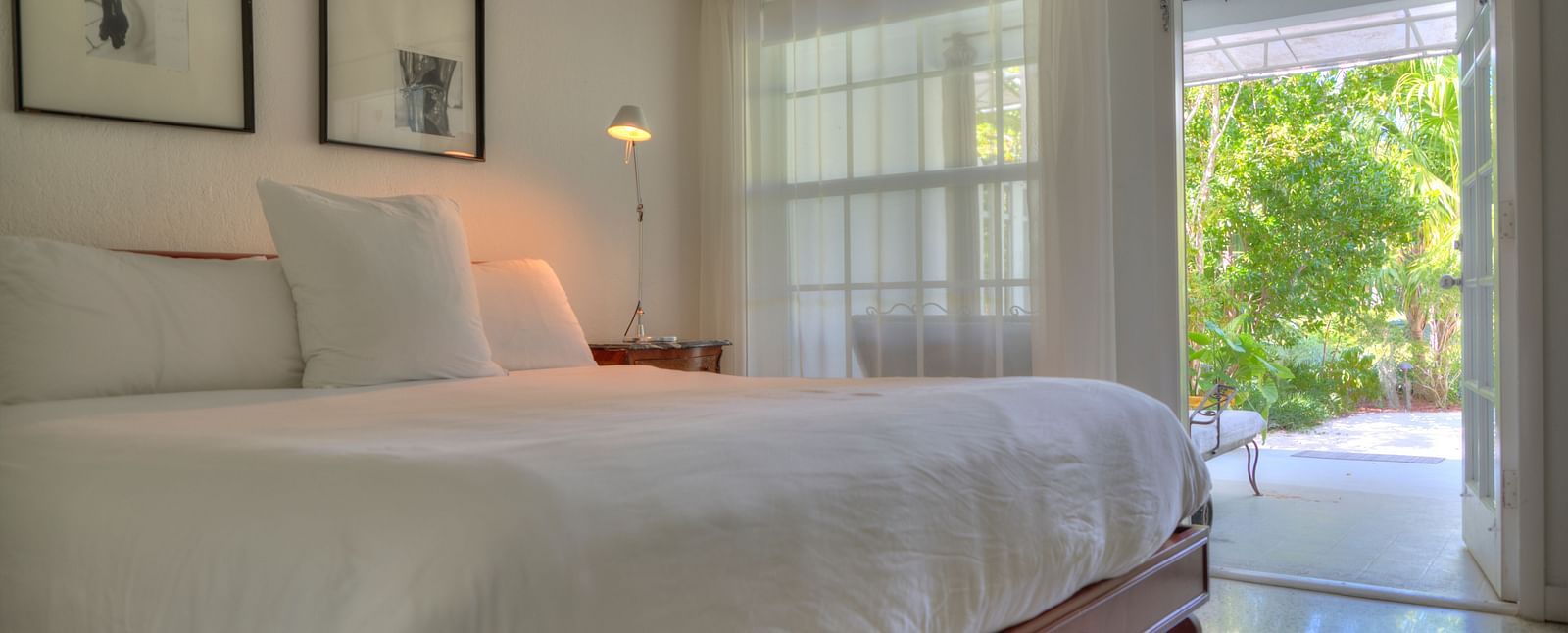 a spacious bedroom with a huge bed and a door leading to the garden at Casa Morada.