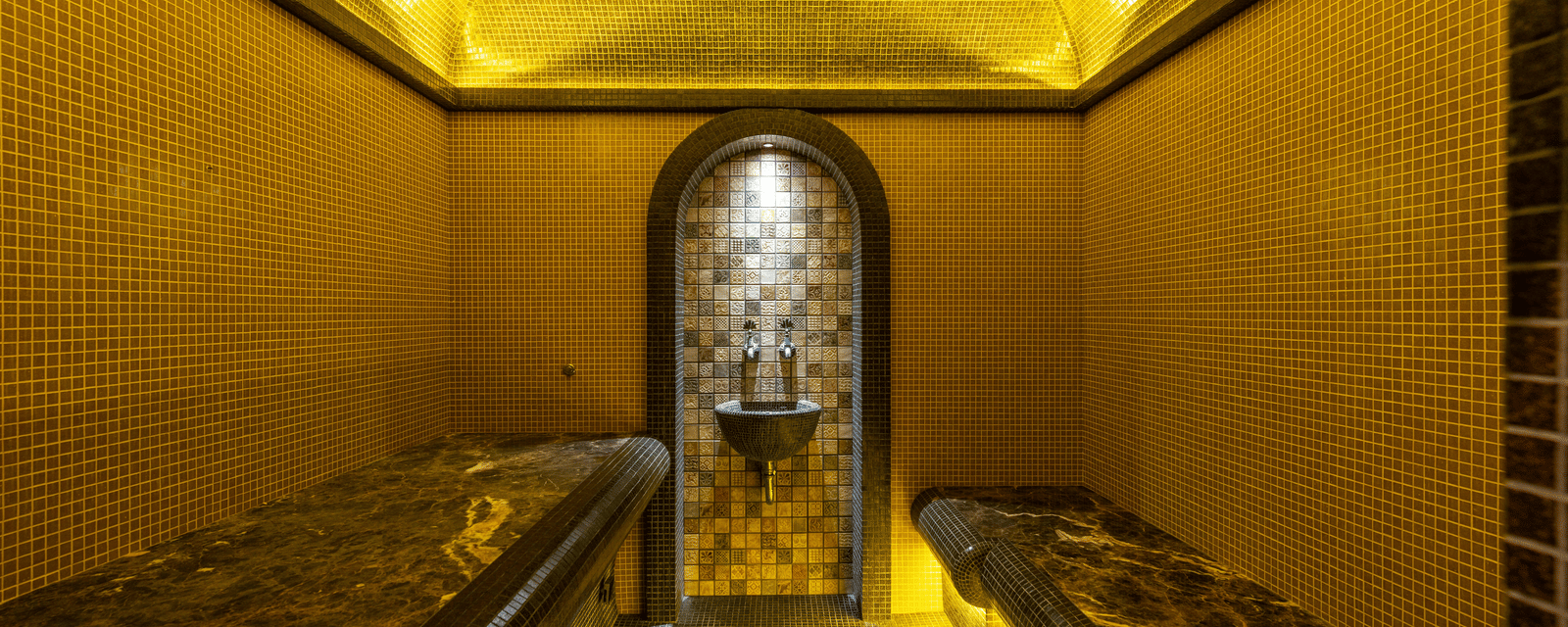 Close-up of a small, narrow chamber or shrine, illuminated entirely in bright golden light focusing on a central object.