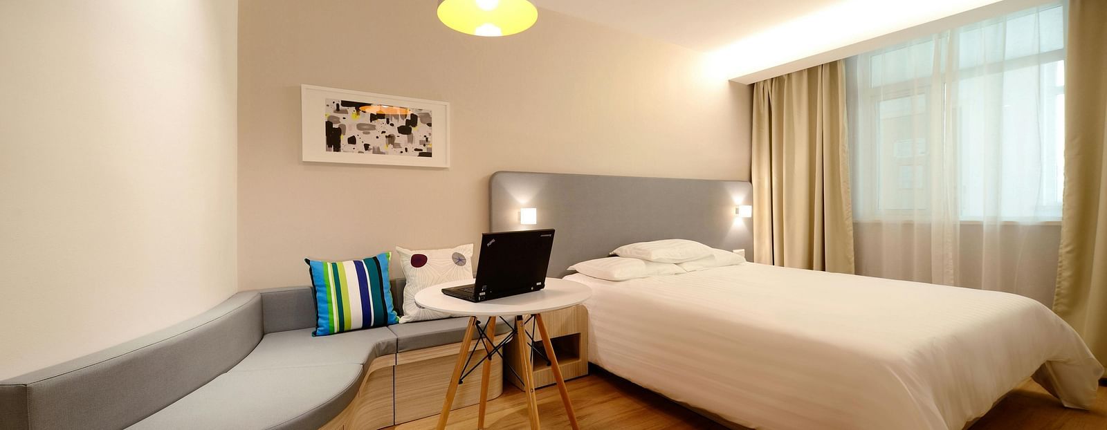 Another view of a room with a comfortable bed, ambient lighting, cosy furniture and a television for entertainment