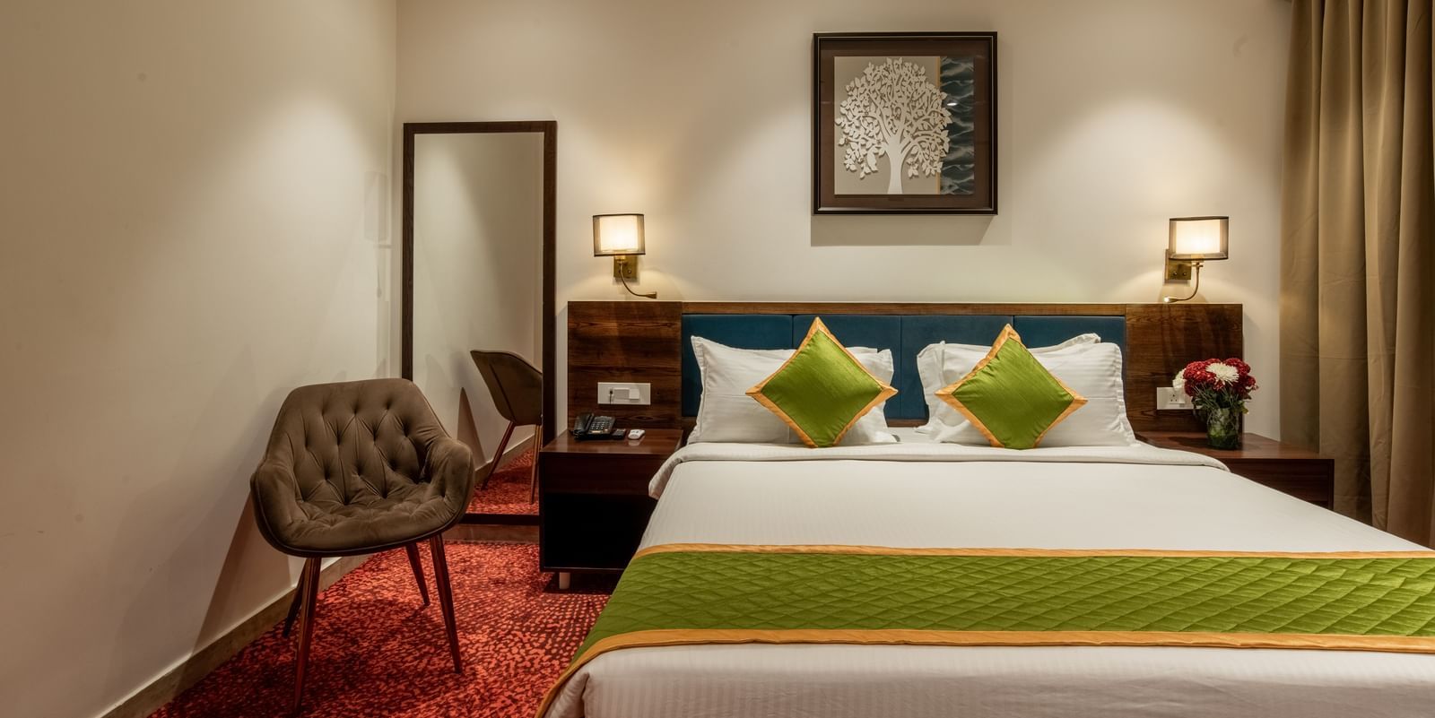 Bedroom with king size bed, wooden furniture, and warm lighting at Hotel Royal Regency Chennai