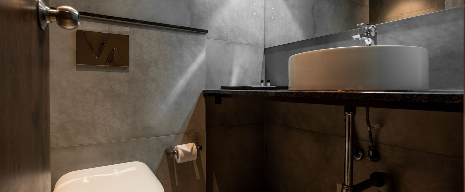 Modern bathroom with toilet, sink, and shower area at Hotel Royal Regency Chennai