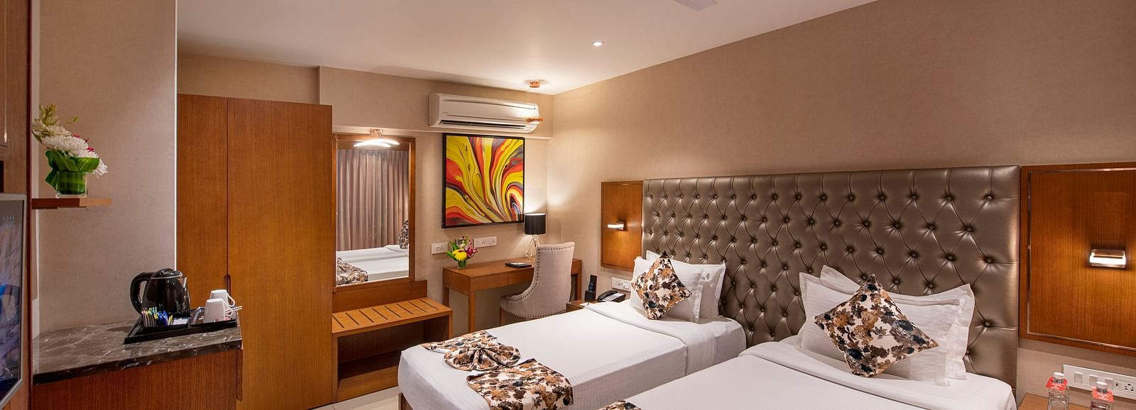 Twin bed room with bed post, dressing table with mirror, side table and AC