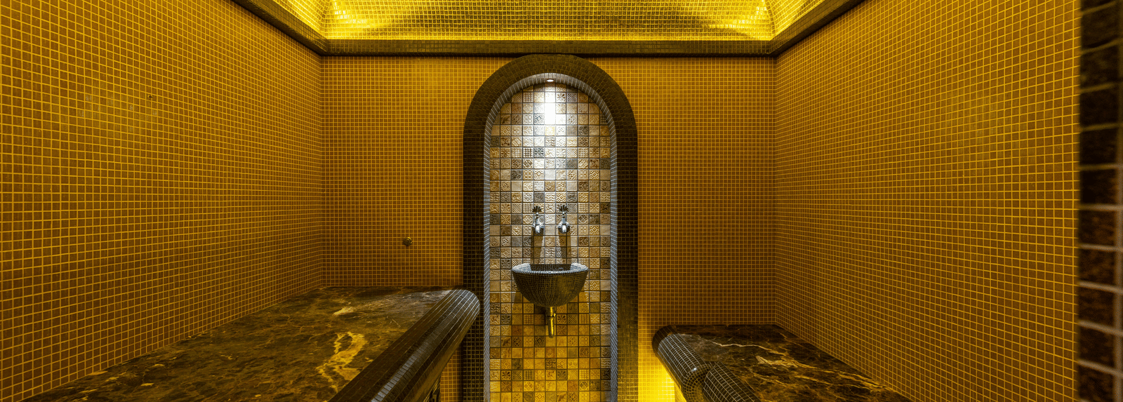 Close-up of a small, narrow chamber or shrine, illuminated entirely in bright golden light focusing on a central object.