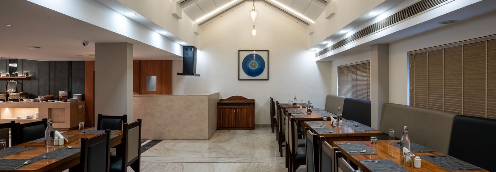 Well-lit restaurant with contemporary seating arrangement at Hotel Royal Regency Chennai