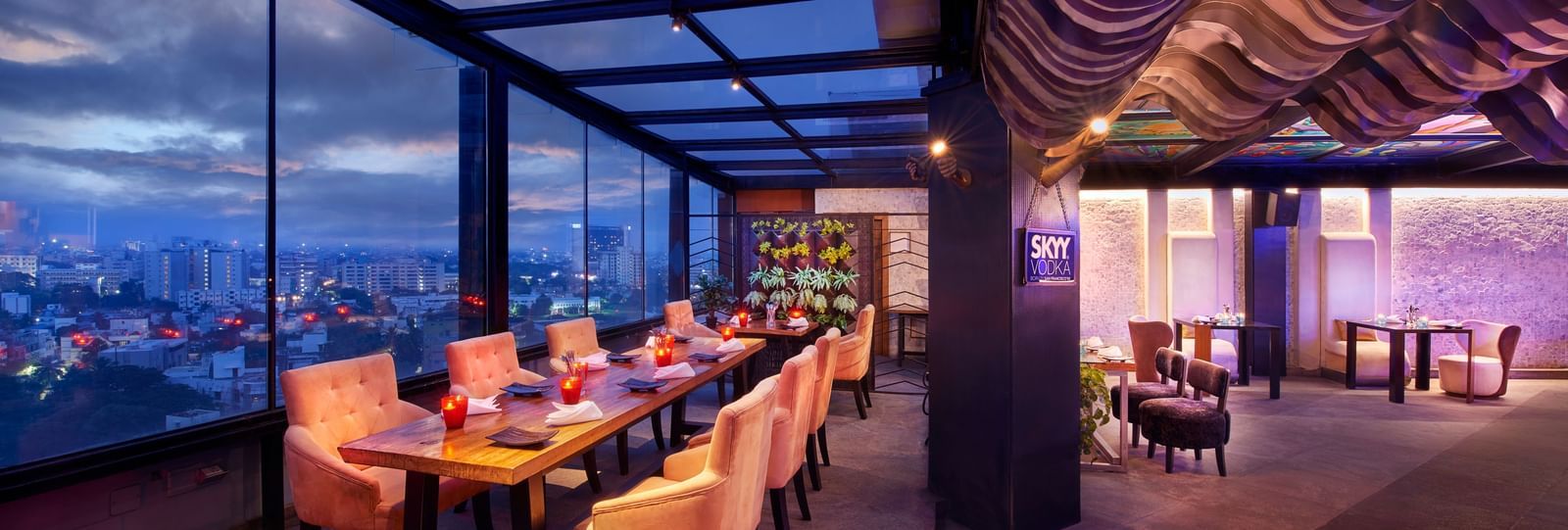 An image of a restaurant at the roof top featuring a seating area with tables and chairs at Accord Hotels and Resorts