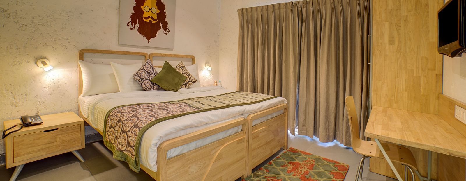 A large bedroom with a large bed with two side drawer and side lamps facing a television - Bedzzz, Rishikesh