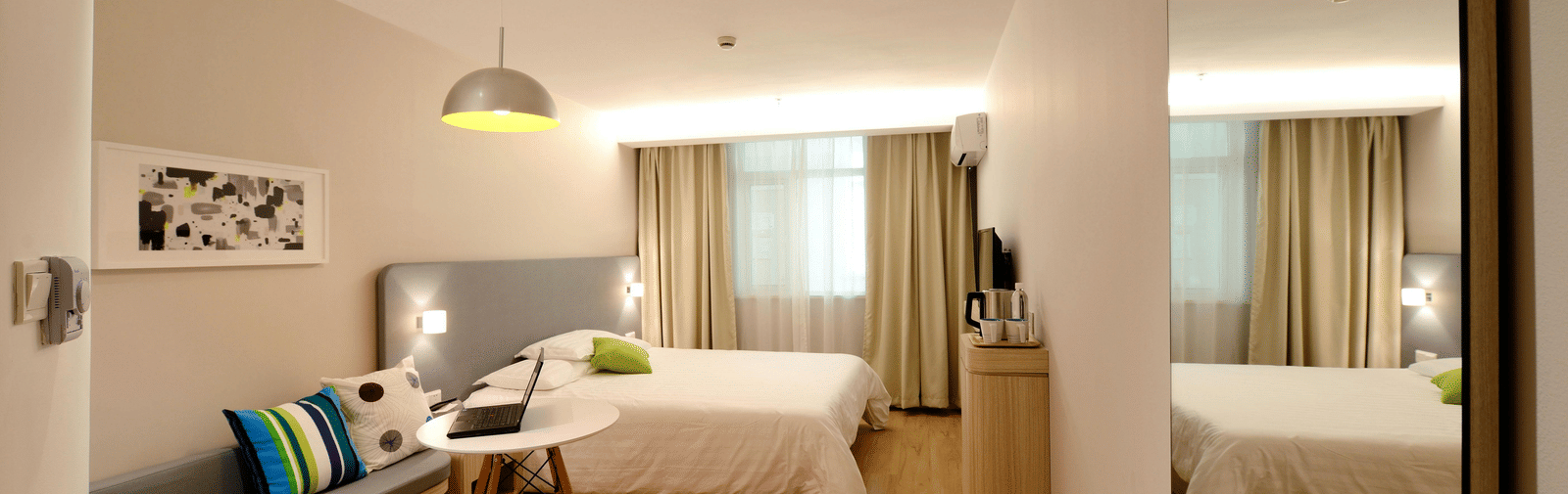 A bright, modern suite with a sitting area and a king size bed.