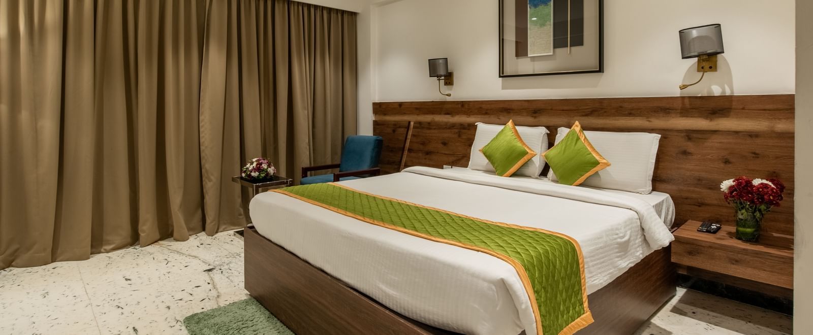 Bedroom with stylish decor, green accents, and wooden furnishings at Hotel Royal Regency Chennai