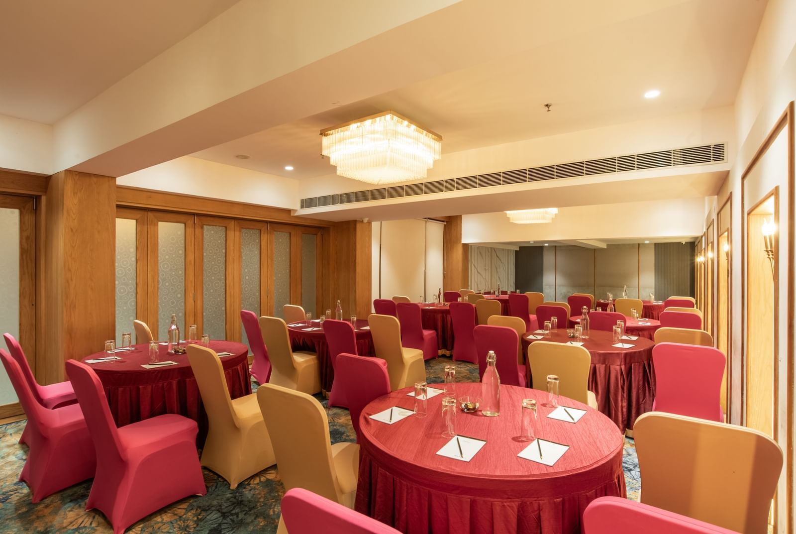 Spacious banquet hall with decorated tables and chairs at Hotel Royal Regency Chennai