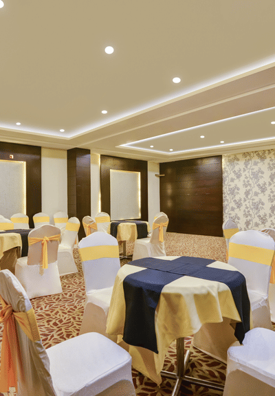 A shot of white table and chairs arranged for an event t the banquet hall.