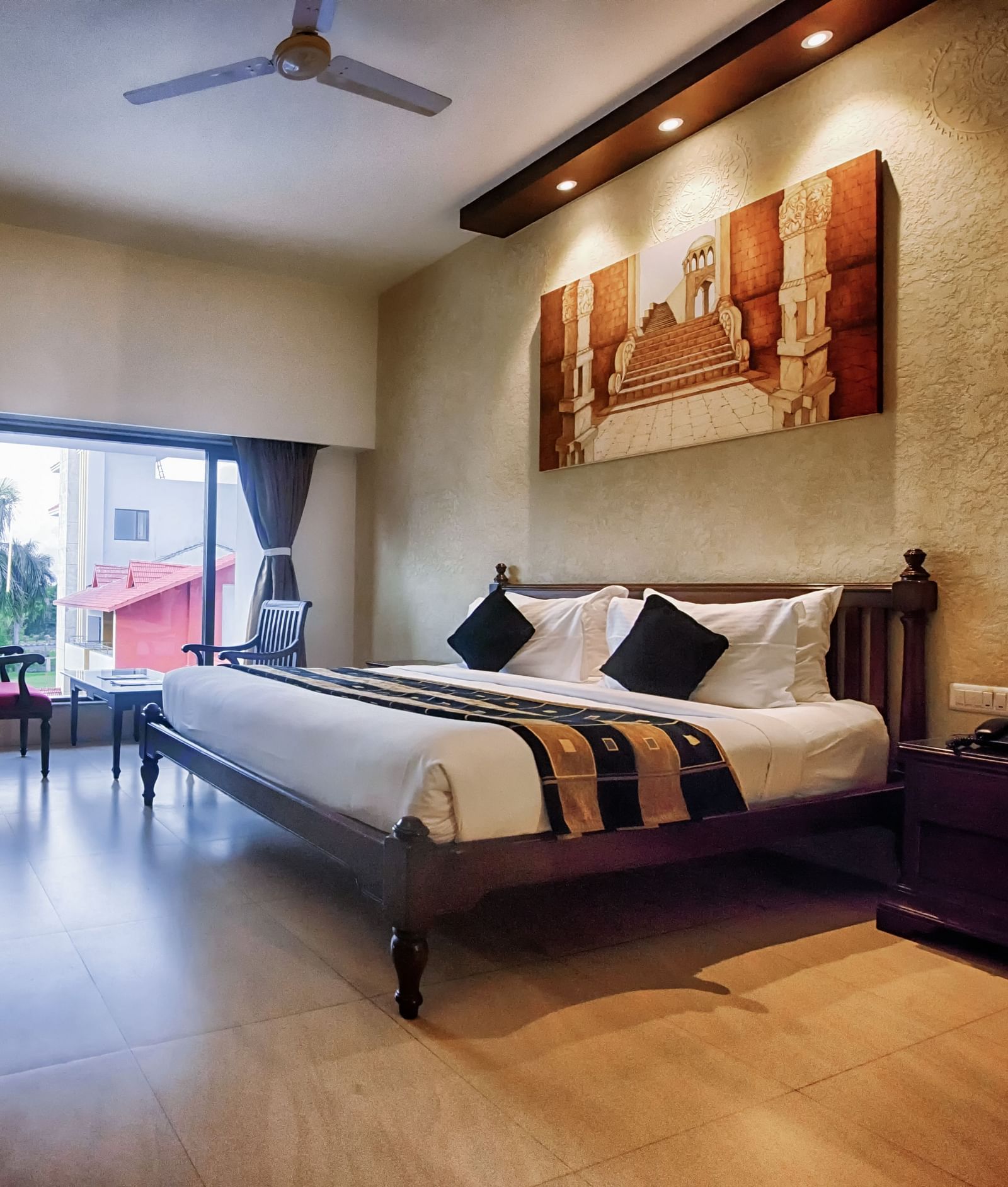 Club Room at Crescent Resort, Sehore featuring a plush bed facing a TV mounted on the wall and a sitting space next to the large window