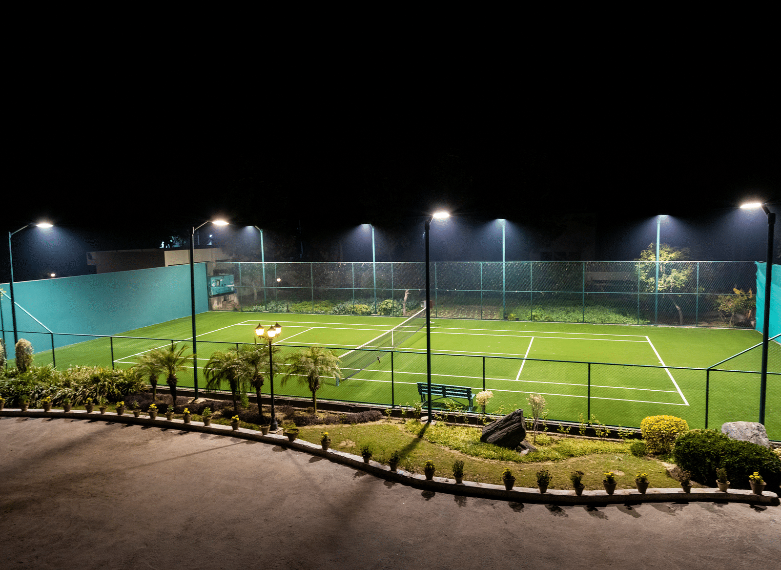 A view of a well-lit tennis court at BluSalzz Resort.