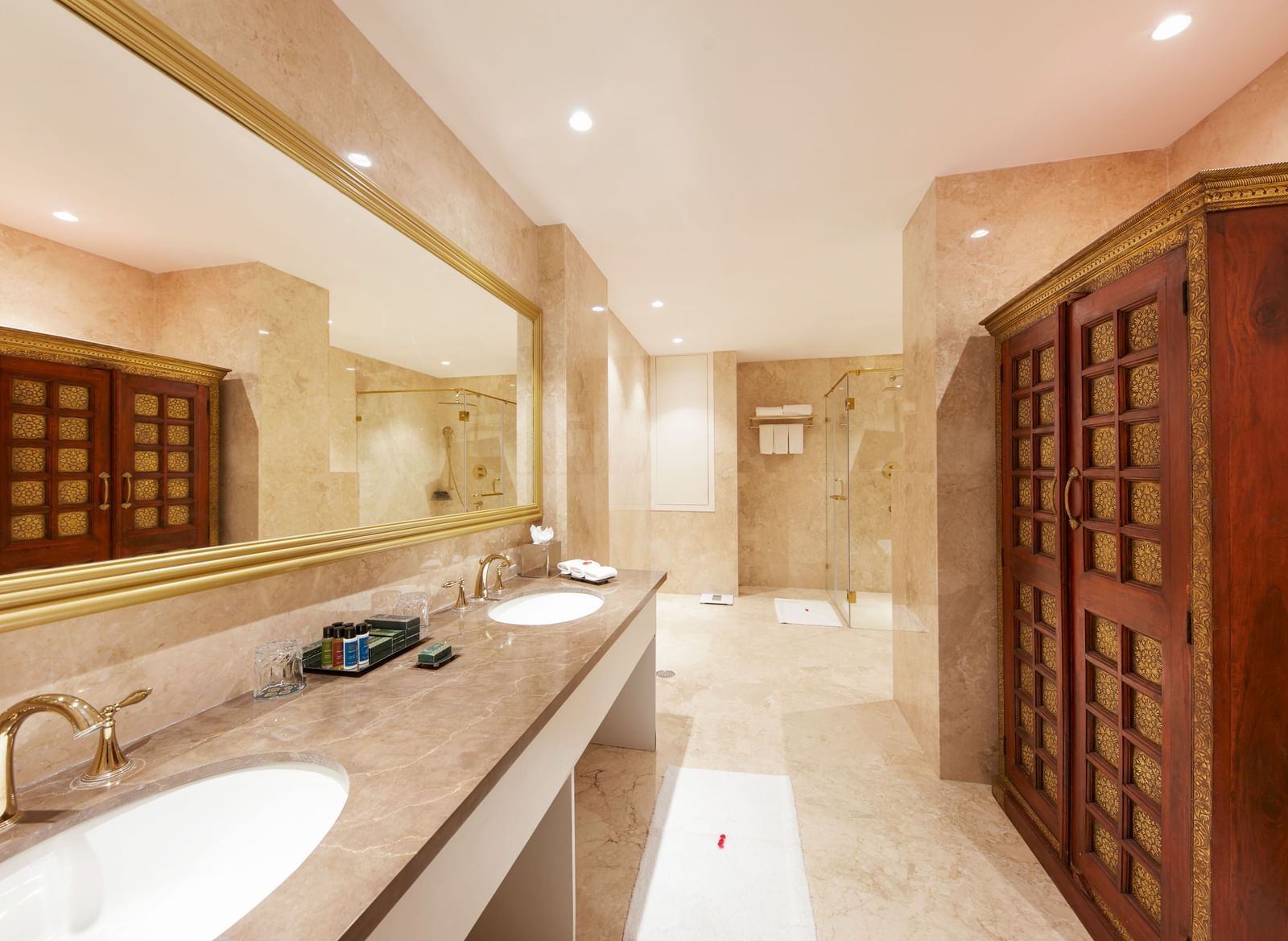A marble bathroom with dual sinks and wooden cabinetry – Kaldan Samudra, one of the finest five star resorts in Mahabalipuram