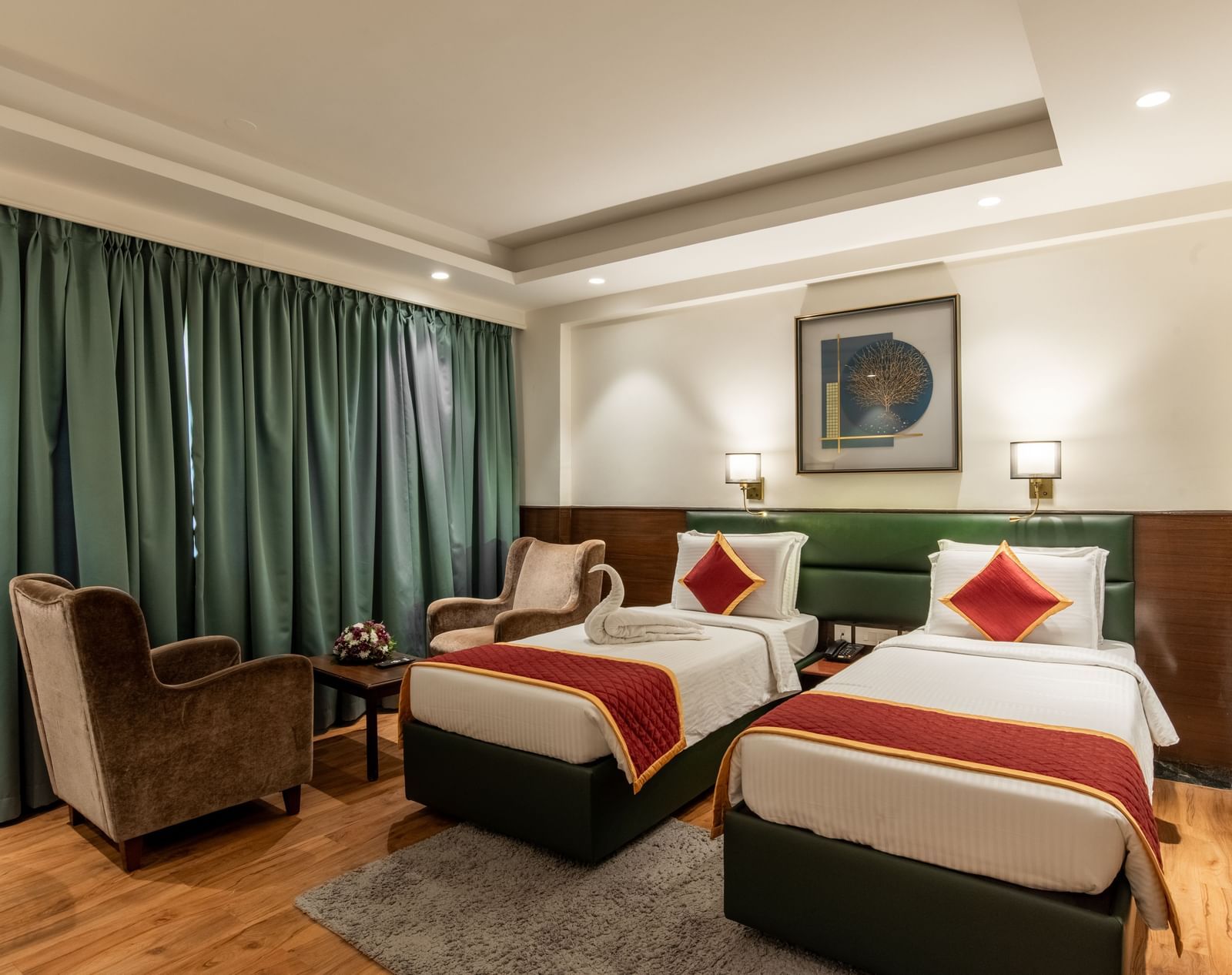Spacious twin bedroom with comfortable seating and decor at Hotel Royal Regency 
