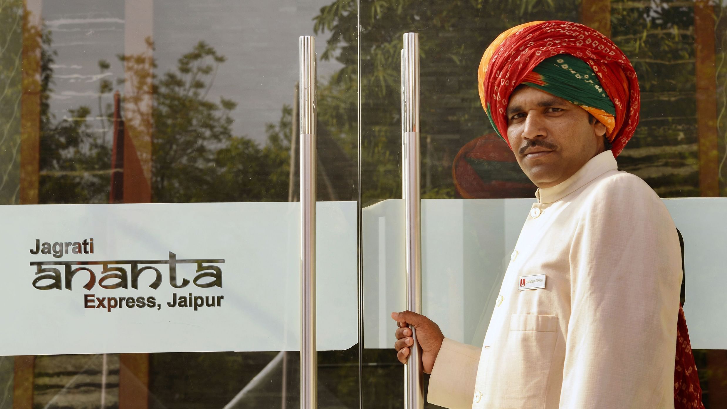 A person opening the entrance door of Jagrati ananta  express hotel