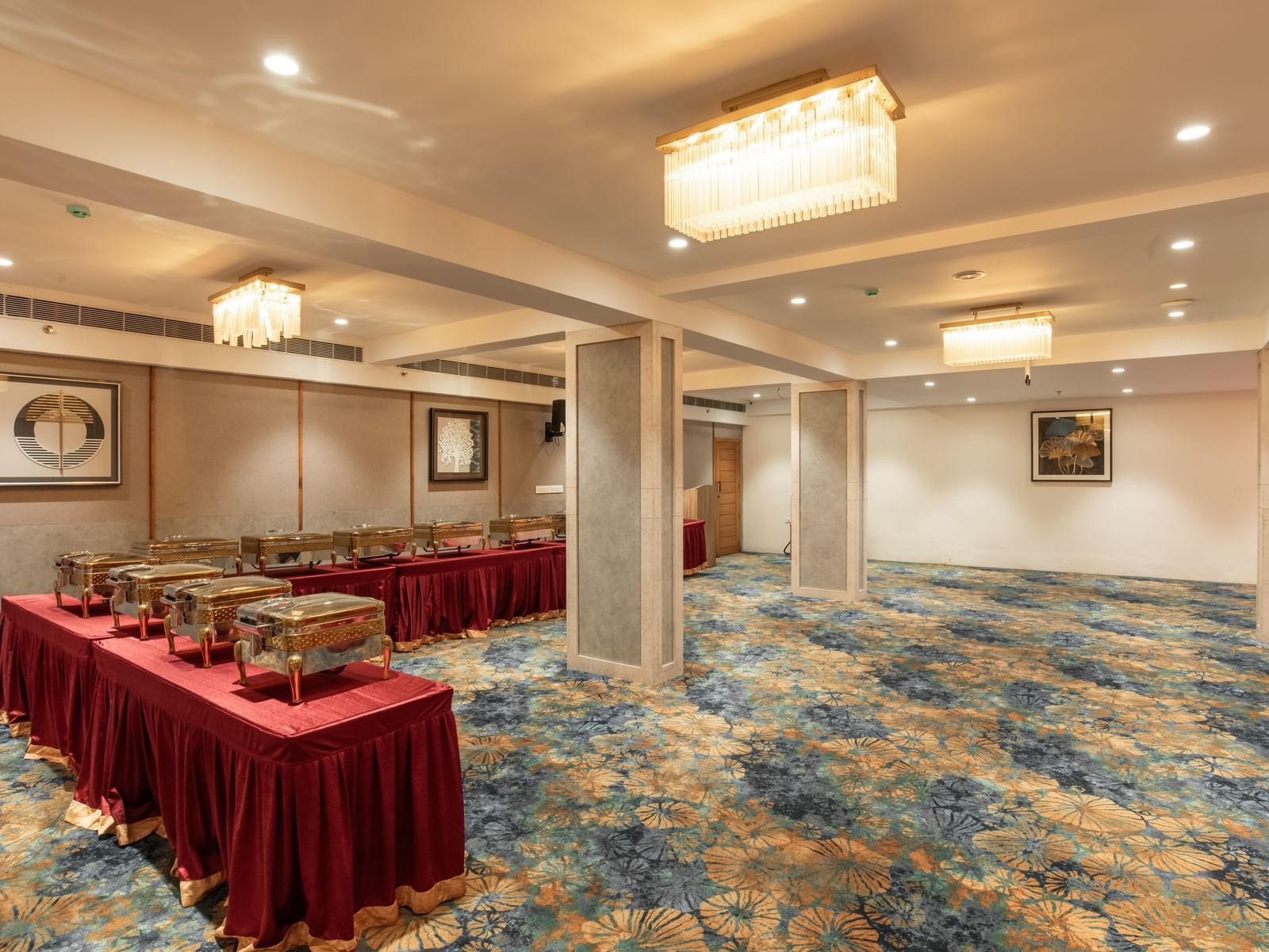 Banquet hall with round table setup and elegant chandeliers at Hotel Royal Regency Chennai