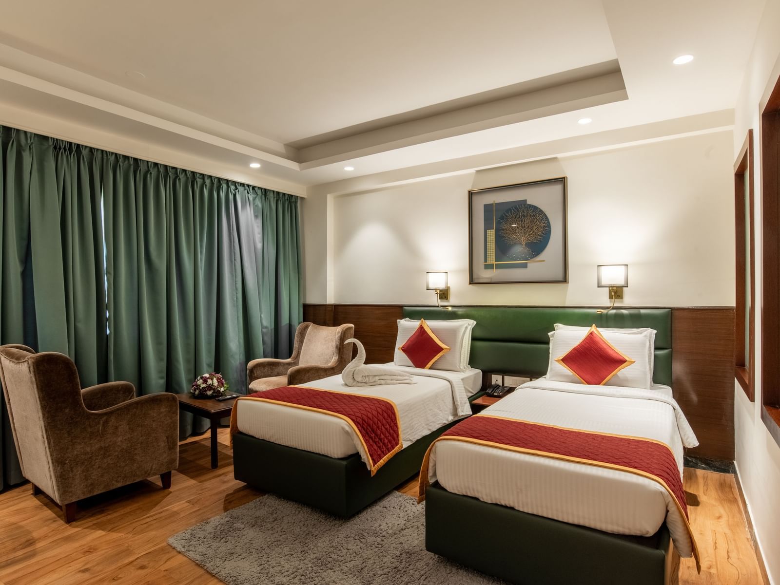 Spacious twin bedroom with comfortable seating and decor at Hotel Royal Regency 