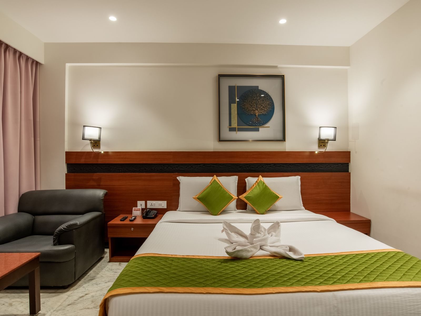 Spacious bedroom with king size bed, seating area, and elegant lighting at Hotel Royal Regency Chennai