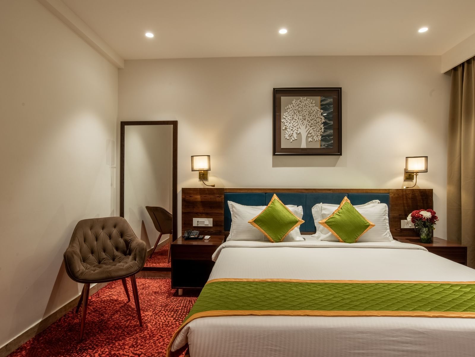 Bedroom with king size bed, wooden furniture, and warm lighting at Hotel Royal Regency Chennai