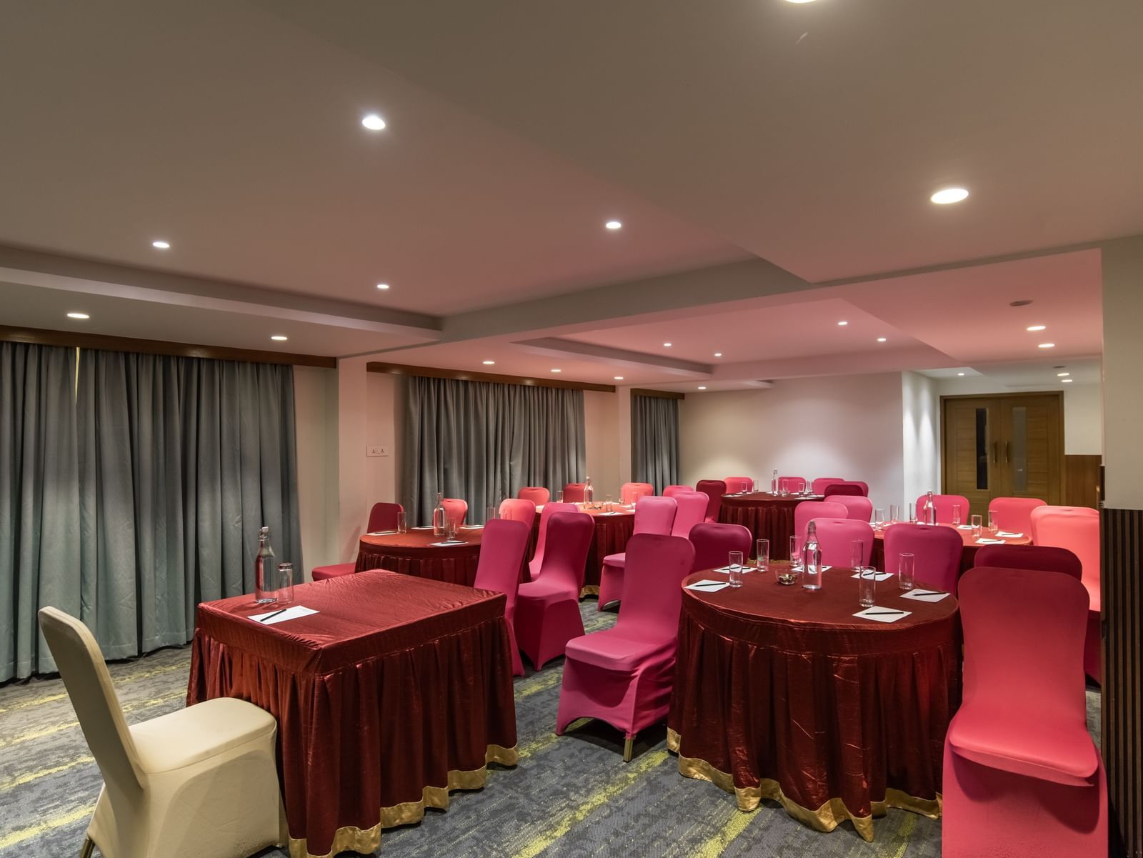 Event space with rectangular tables and cushioned seating at Hotel Royal Regency Chennai