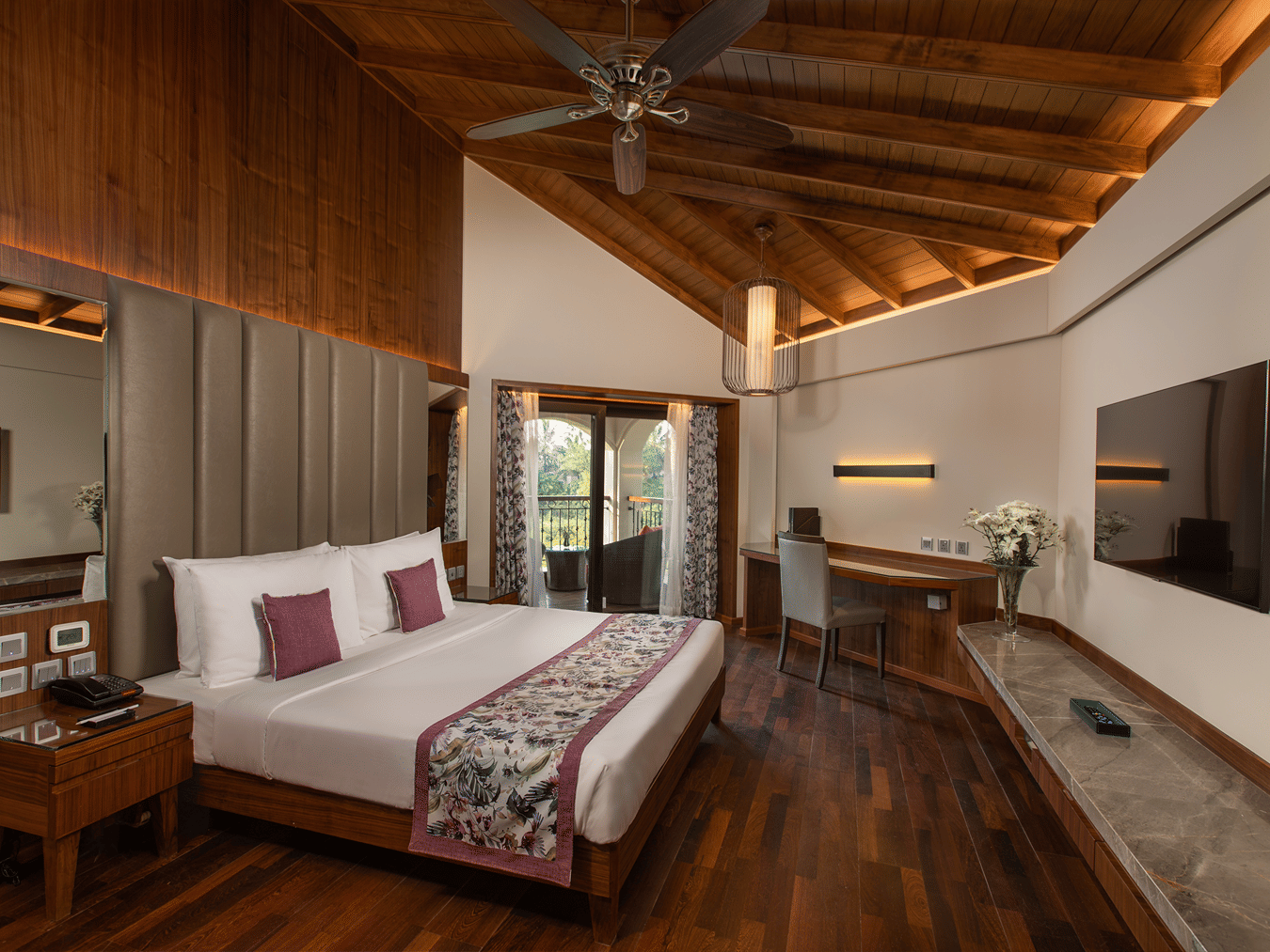 Pool View Suite King Bed looks neat in a mostly-white bedding surrounded by white walls and wooden furnishing at Kenilworth Resort & Spa, Goa