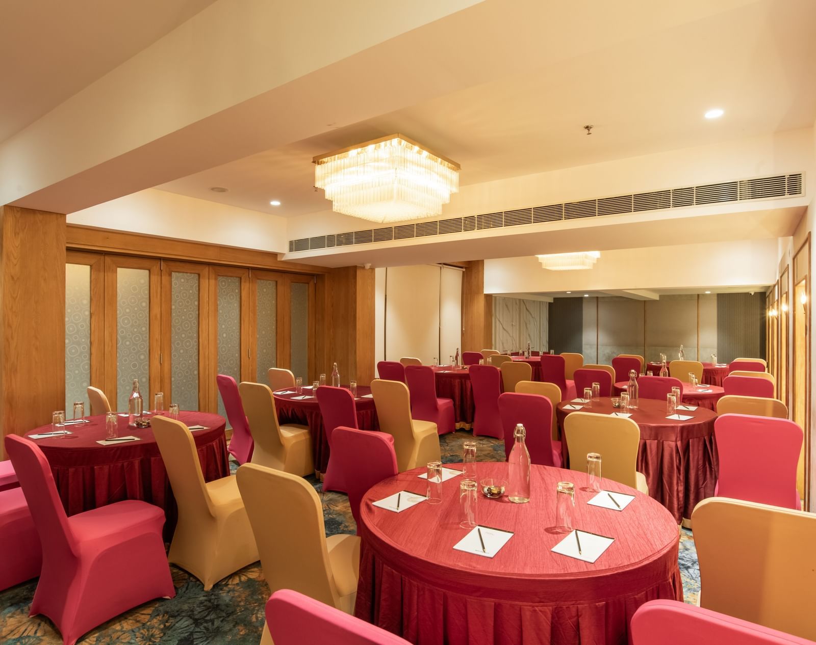 Spacious banquet hall with decorated tables and chairs at Hotel Royal Regency Chennai