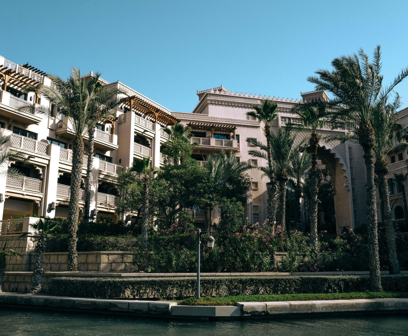 An exterior view of a residential or resort building with palm trees and balconies.