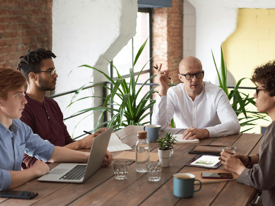 A Business meeting with 4 people discussing around a table