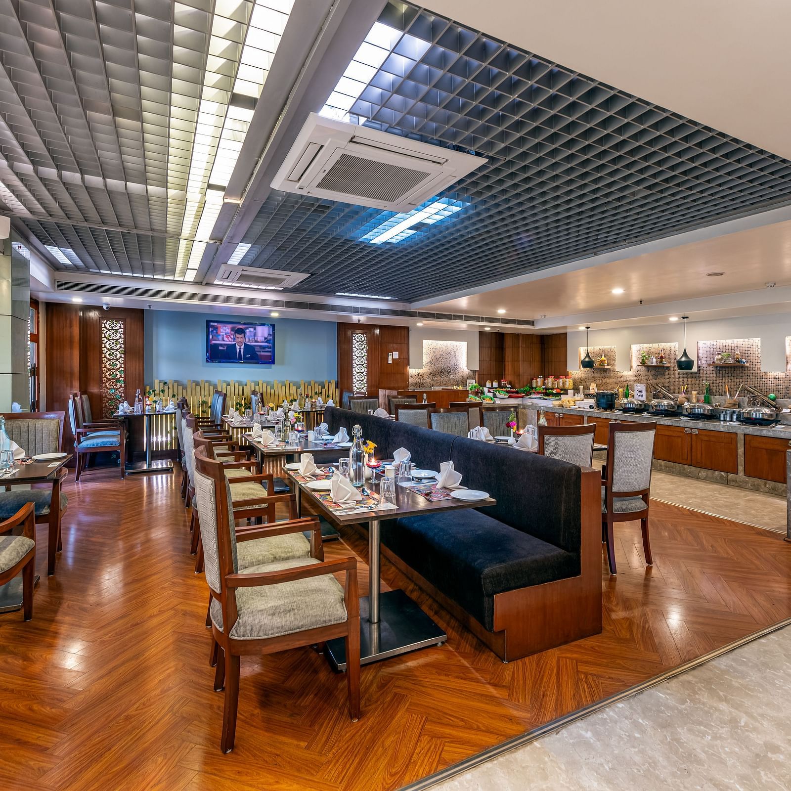 Spacious dining area with multiple tables and decorative ceiling at Lords Plaza Jaipur.