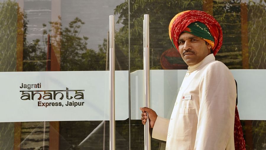 A person opening the entrance door of Jagrati ananta  express hotel