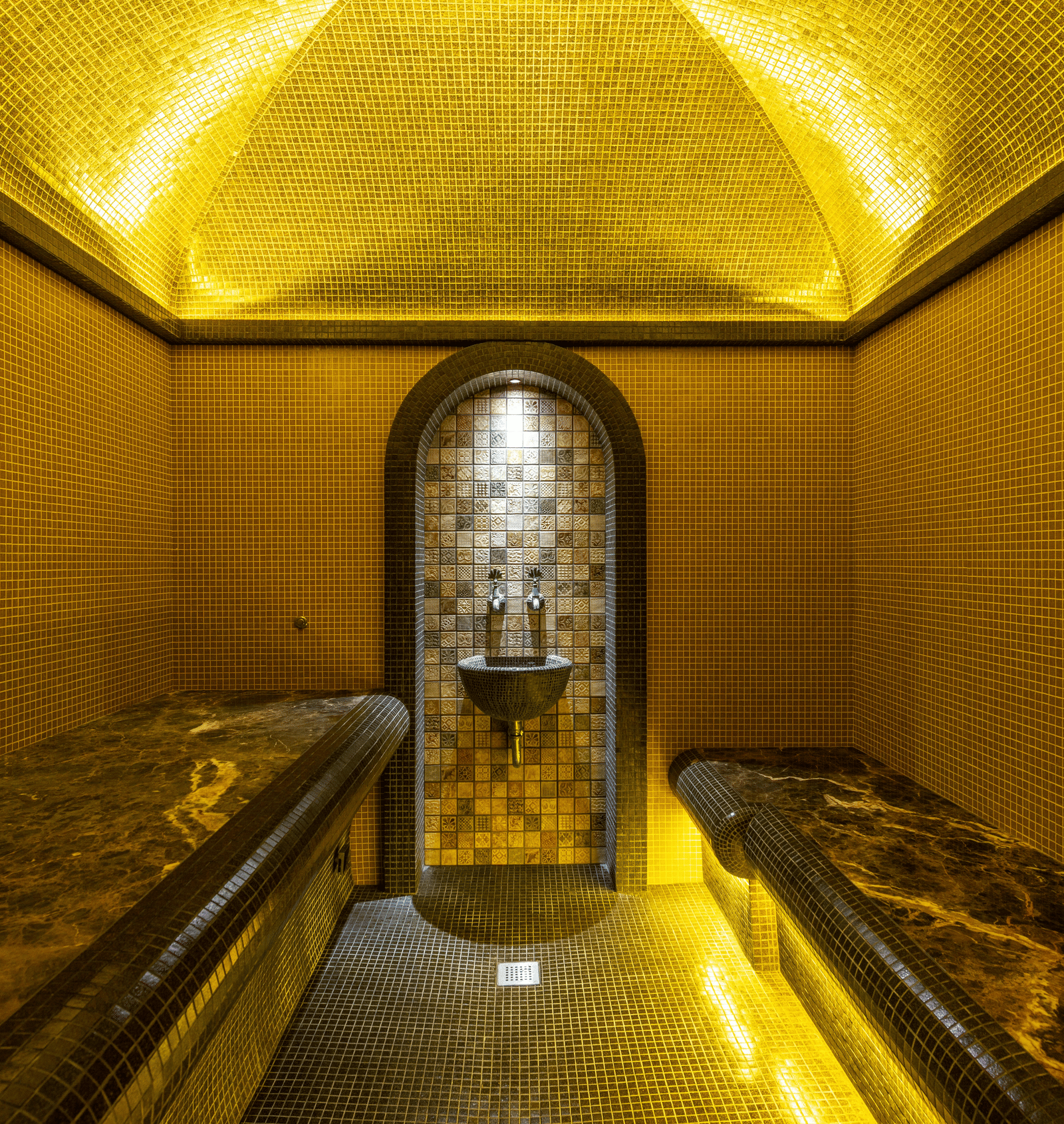 Close-up of a small, narrow chamber or shrine, illuminated entirely in bright golden light focusing on a central object.