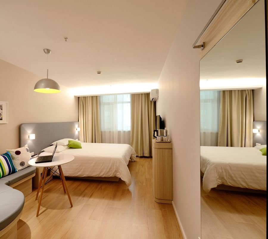 alt-text Spacious Room with warming lighting along with furniture besides the bed