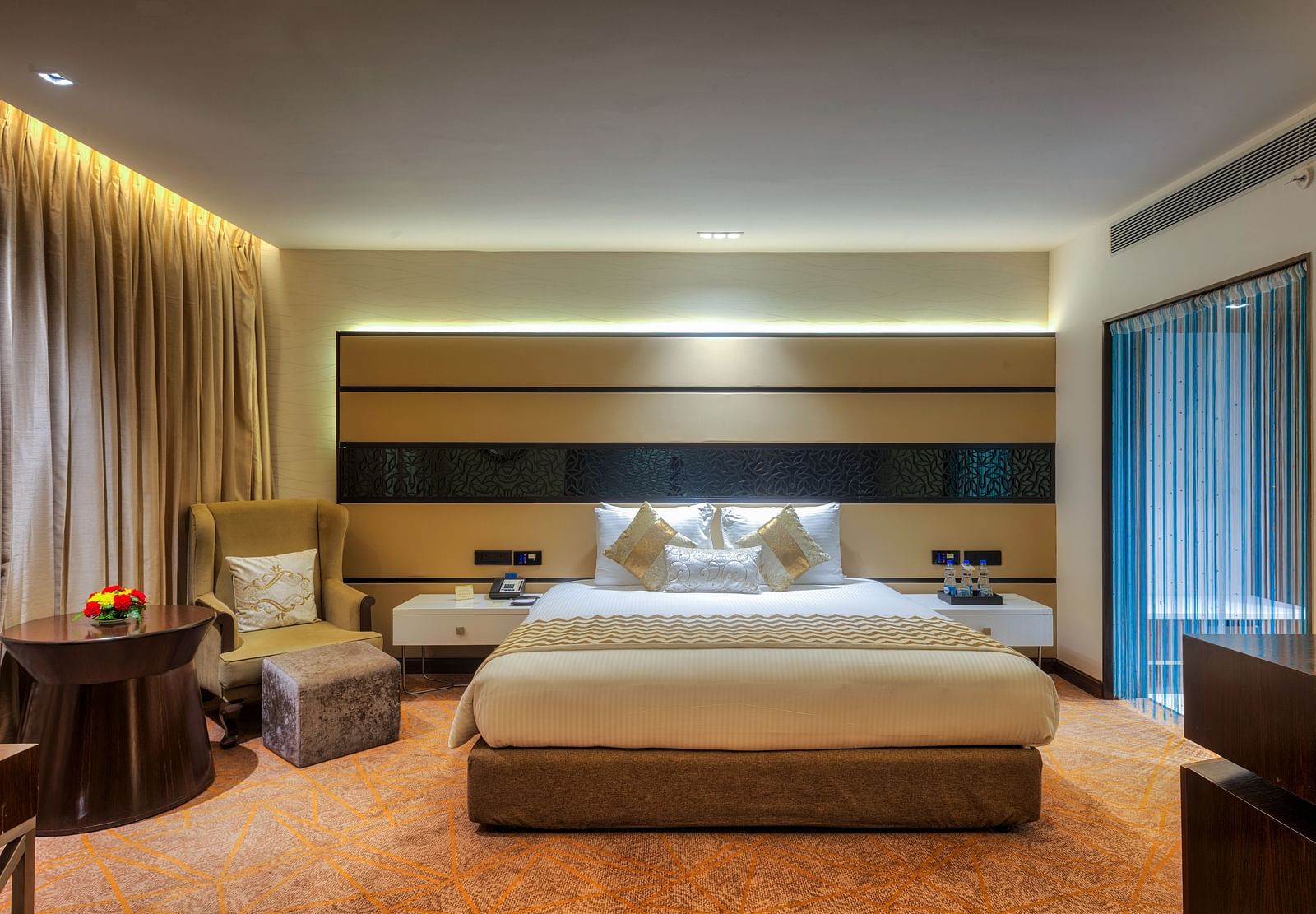 Theme Suite with a king size bed and a sofa chair at Grand Chennai By GRT Hotels.