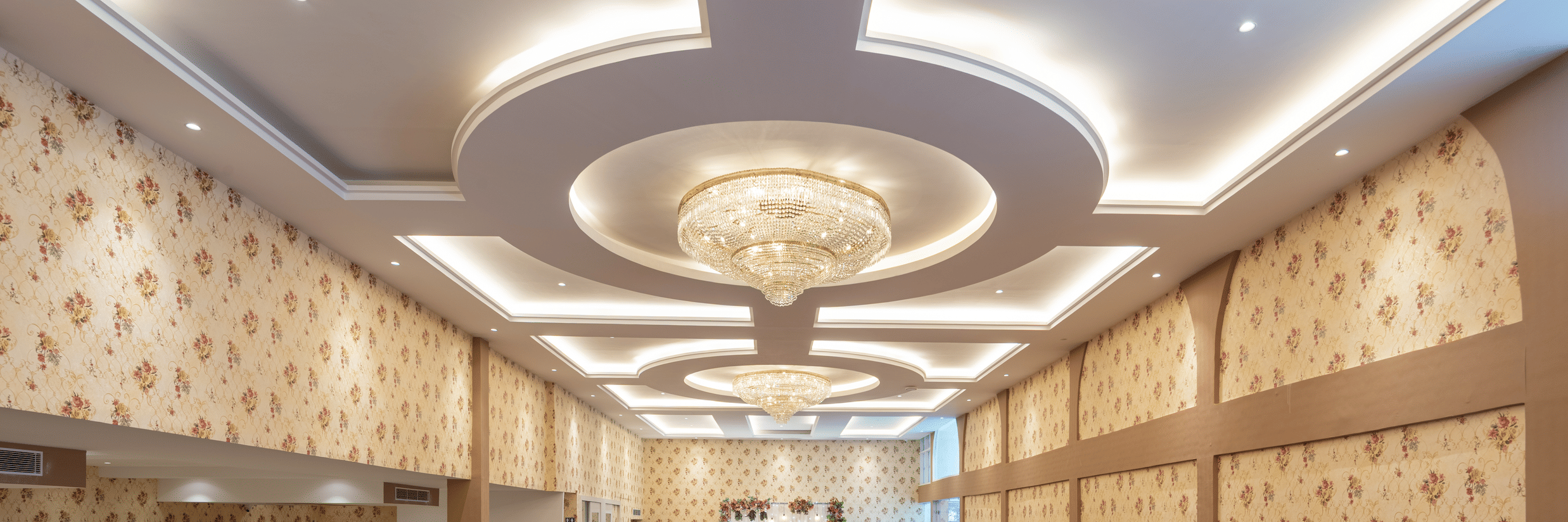 Banquet hall set up with round tables in maroon and white linen at Mango Grove Hotel.