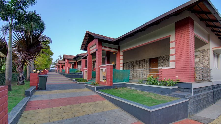 A view down a pathway at Woodstock Resorts, Coorg showing the layout of the buildings and landscaping.
