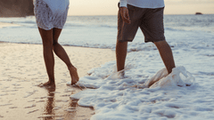 man and woman walking on the beach