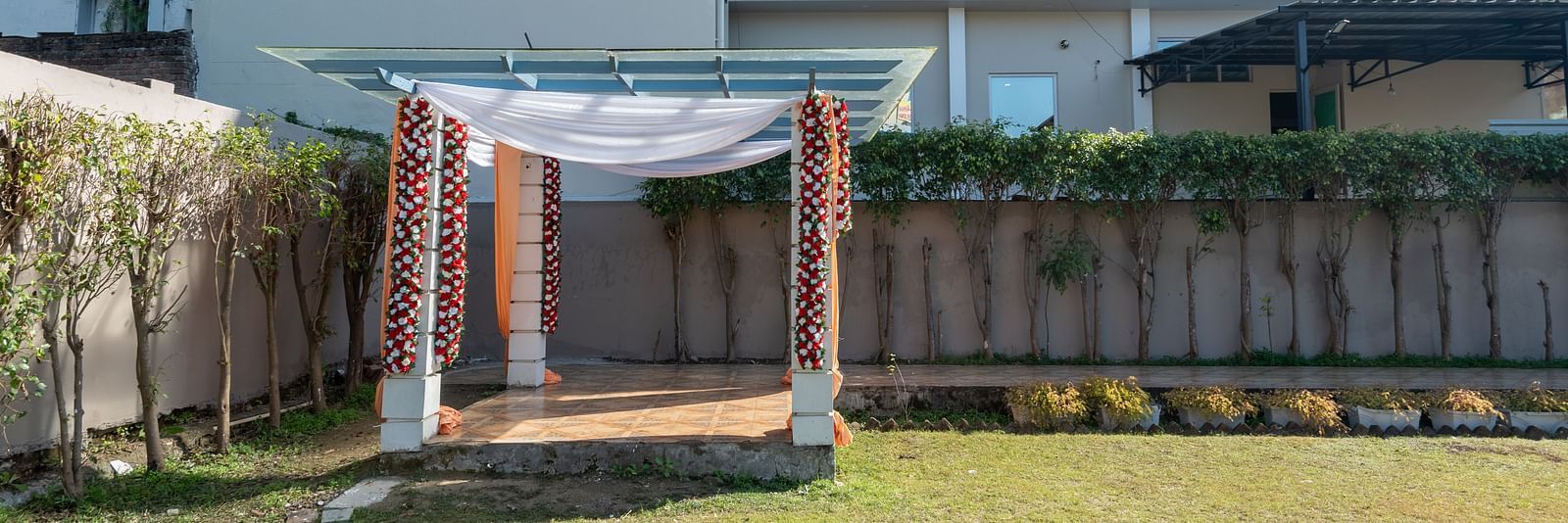A decorated stage setup for an event in the lawn area at DLS Park Grace, Haridwar.