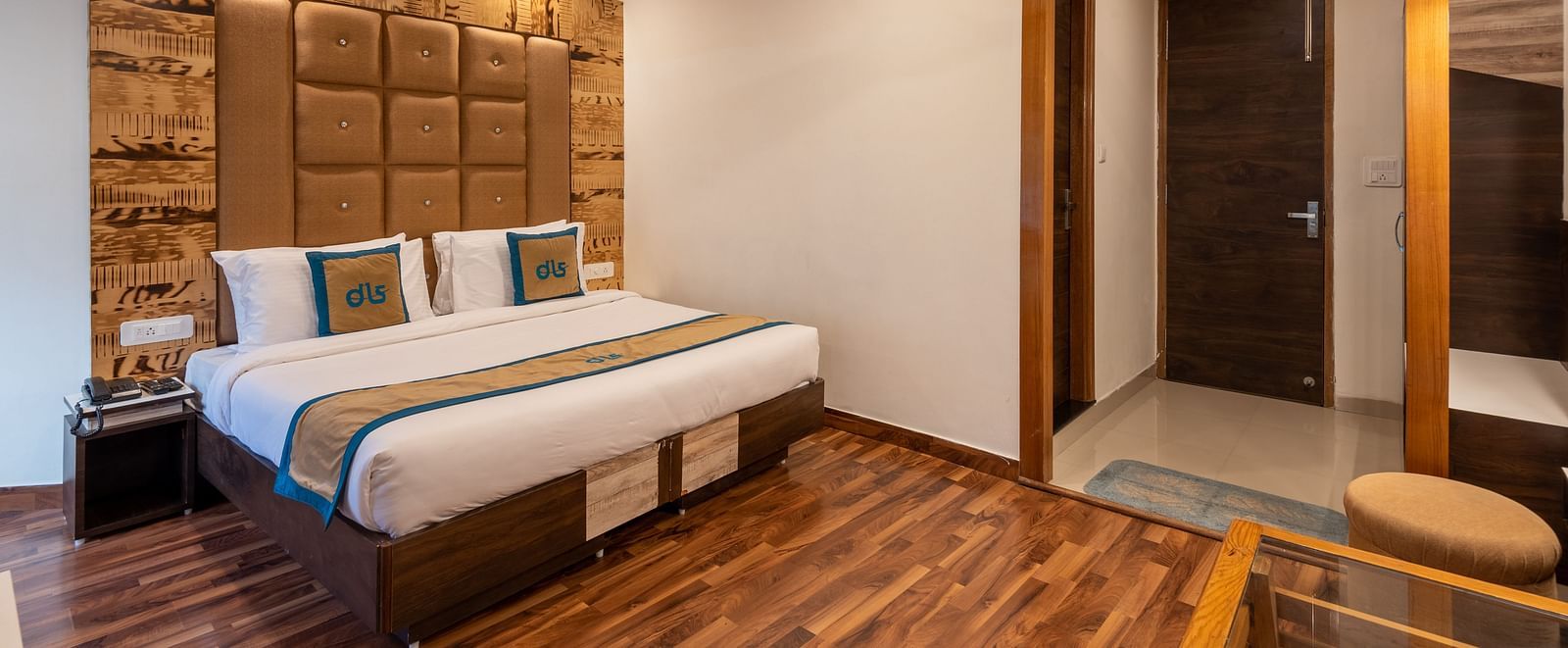 A premium room with modern decor, wooden accents, a comfortable bed, and a warm ambience, featuring essential amenities for a relaxing stay - DLS Meghavan Resort, Dharamshala