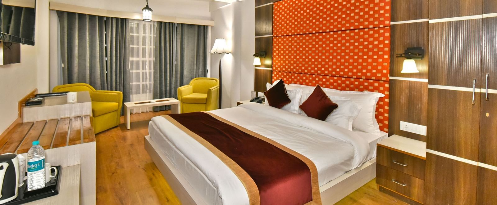 A bedroom with a tea and coffee maker and a seating area with chairs at DLS Hillcrest Resort, Shimla.