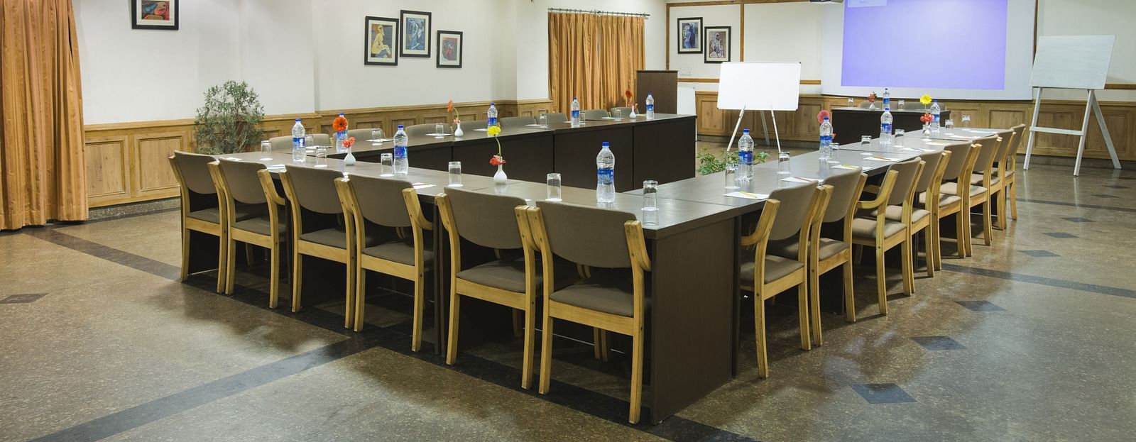 a corner view of a conference room with a U-shaped seating arrangement 