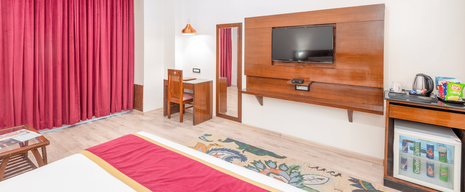 Bedroom with bed, TV, and minibar at DLS Hotels On The Ganges.