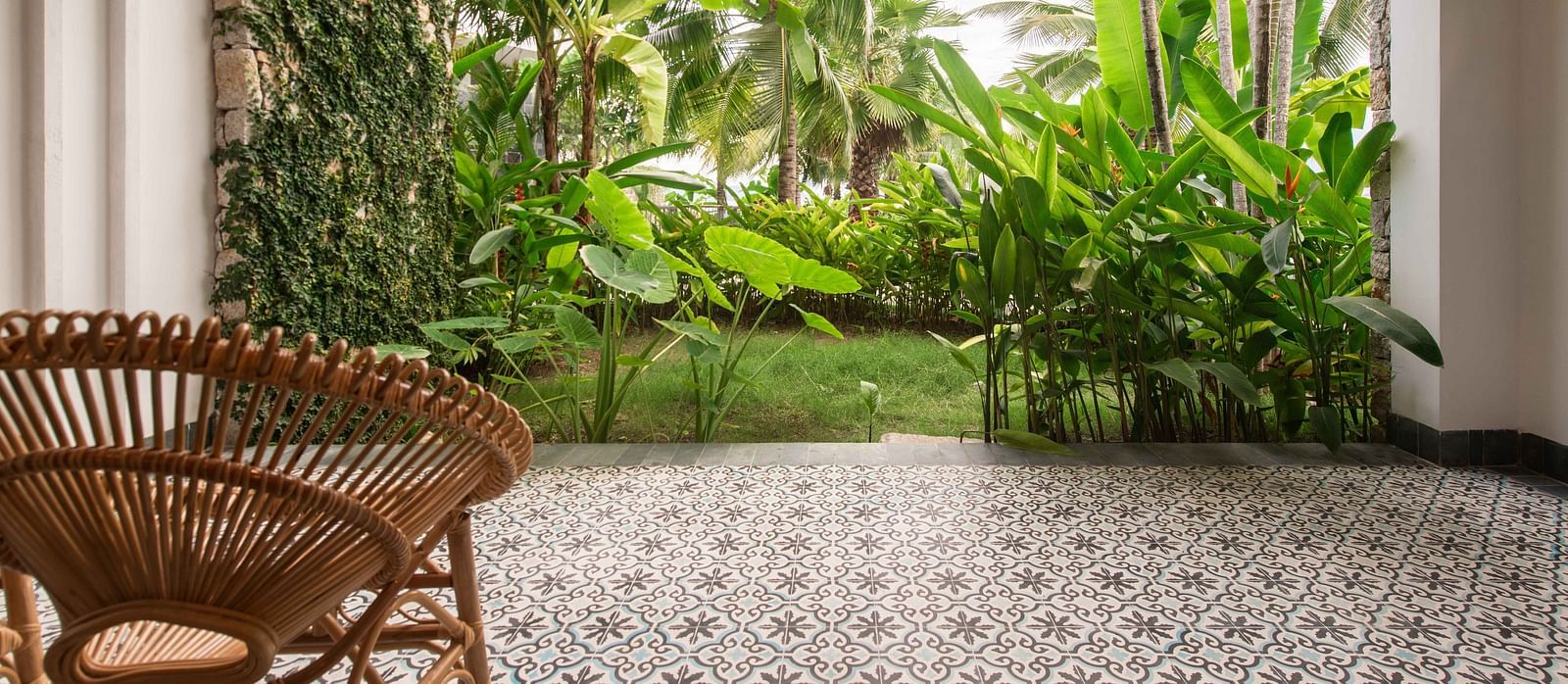 A balcony with a wooden chair to sit and relax and enjoy the garden view - Alibu Reosrt Nha Trang