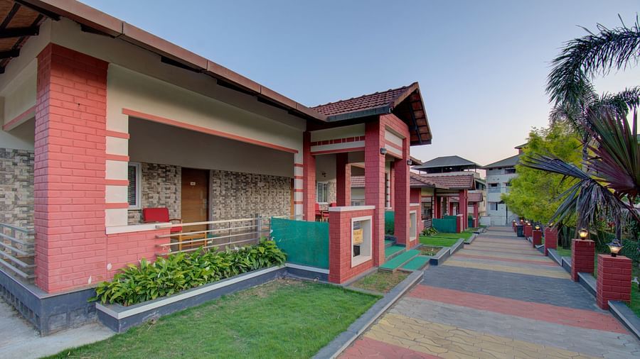 A long shot of the building exterior and lawn area at Woodstock Resorts, Coorg.