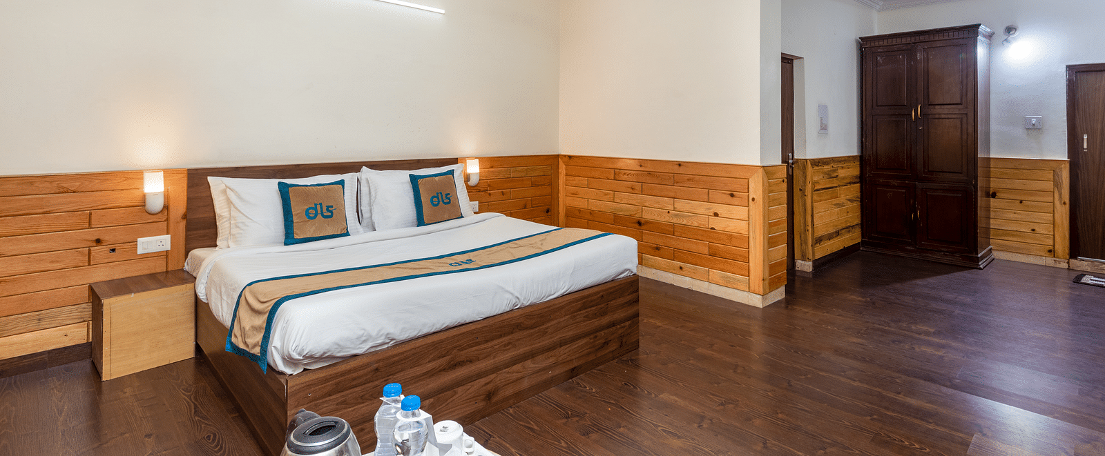 Image of well furnished room featuring a king size bed and a large open space with wooden flooring | DLS Anupam Resort, Dharamshala