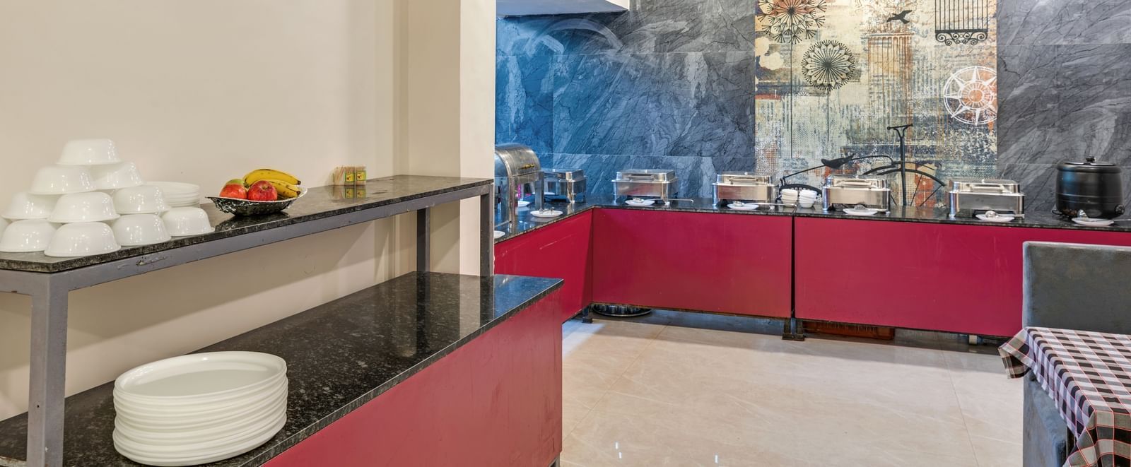 Buffet counter setup with white ceramics and steel utensils in the dining area at Emerald Retreat, Tungarli.