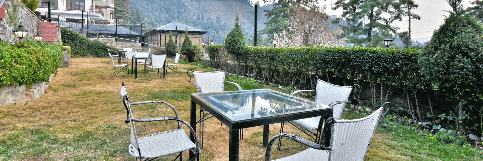 Lawn with chairs offering garden views at the best resort near Shimla. - DLS Hillcrest Resort